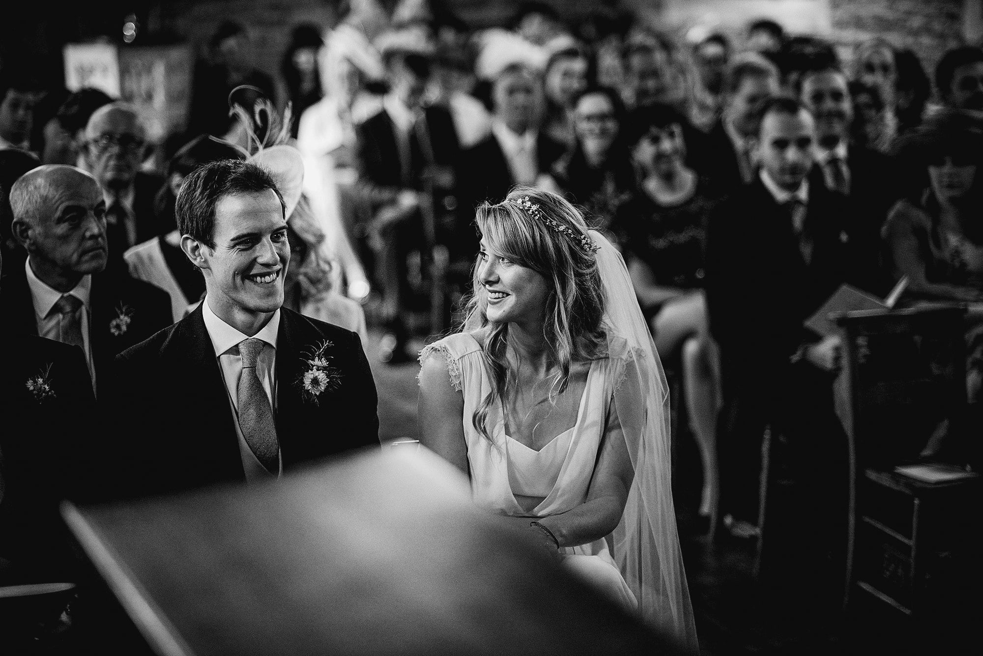 bride and groom during church ceremony in black and white
