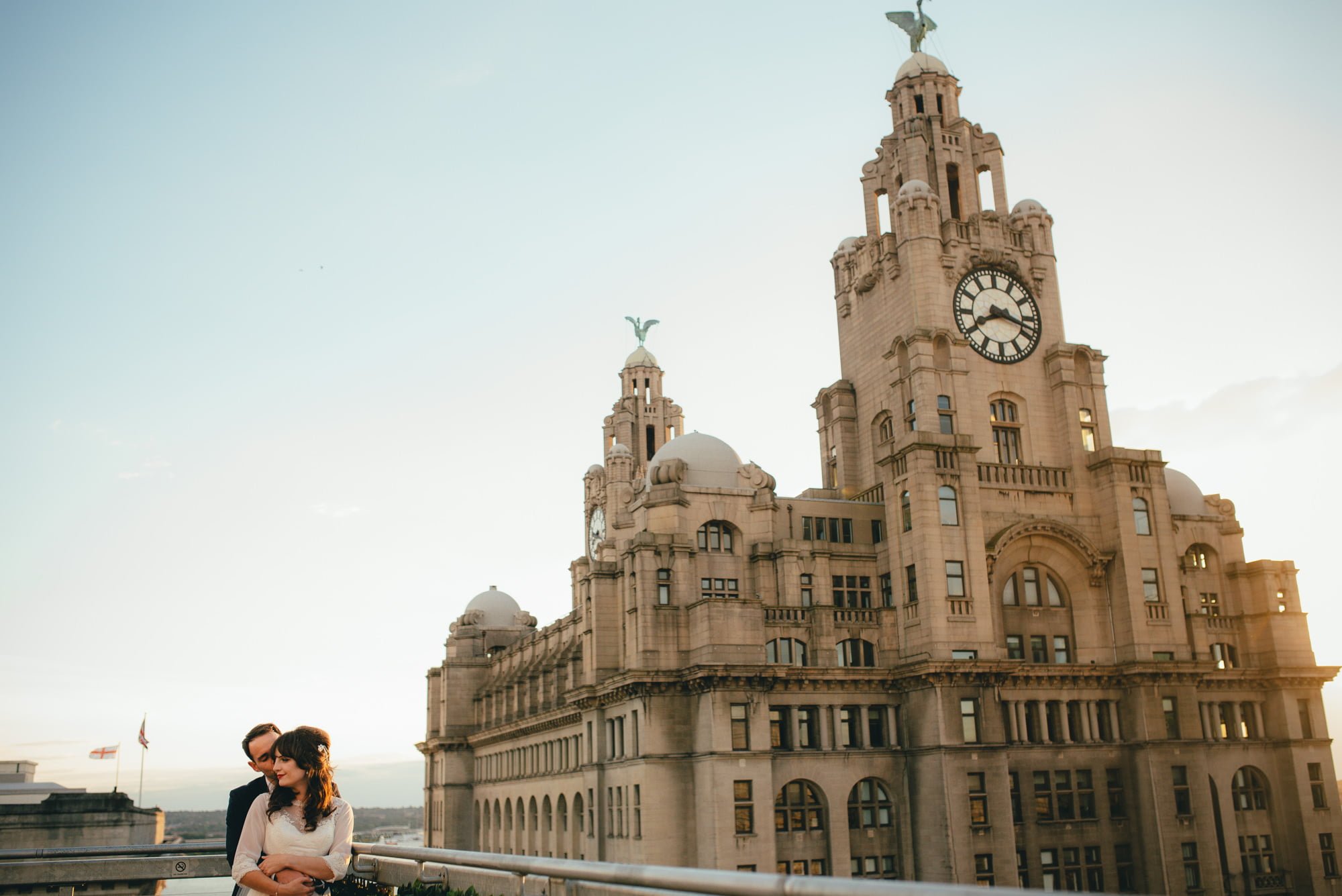 Oh my oh my wedding photography couple on roof by liver building at sunset